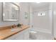 Bright bathroom with vanity, custom sink, and shower-tub combo, and glass accent window at 22 The Prado Ne, Atlanta, GA 30309