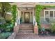 Inviting front porch entry with brick steps, decorative lighting, and lush landscaping at 22 The Prado Ne, Atlanta, GA 30309
