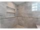 Shower with marble tiling, a built-in niche, and a glass block window for natural light at 22 The Prado Ne, Atlanta, GA 30309