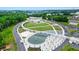 Aerial view of a community park with water features, pedestrian bridge, green space, and playground at 400 Pringle Dr, Suwanee, GA 30024