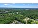 Expansive aerial view of a verdant residential area with mature trees and a distant mountain range at 400 Pringle Dr, Suwanee, GA 30024