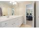 Bathroom vanity featuring double sinks, white cabinets, and views to bedroom at 400 Pringle Dr, Suwanee, GA 30024