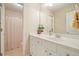 Bathroom vanity with white cabinets, sink, mirror, and decorative plant at 400 Pringle Dr, Suwanee, GA 30024