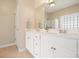 Bright bathroom features double vanity with white cabinets and framed mirror at 400 Pringle Dr, Suwanee, GA 30024