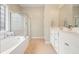 Bright bathroom featuring a double vanity, soaking tub, and a glass-enclosed shower at 400 Pringle Dr, Suwanee, GA 30024