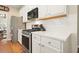 Kitchen featuring stainless steel appliances and white cabinets, with hardwood floors at 400 Pringle Dr, Suwanee, GA 30024
