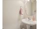 Charming powder room features a pedestal sink and neutral decor for a clean, classic look at 400 Pringle Dr, Suwanee, GA 30024