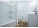 Bathroom featuring a white tub/shower combo, white vanity with matte black fixtures, and wood look flooring at 90 Ayers Rd, Bowdon, GA 30108