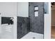 Walk-in shower with black hexagon tile and decorative shelving at 90 Ayers Rd, Bowdon, GA 30108