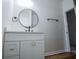 Bathroom featuring a gray vanity with modern hardware, round black framed mirror and matte black fixtures at 90 Ayers Rd, Bowdon, GA 30108