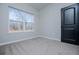 Bright bedroom featuring large window, neutral carpet, and a modern door at 90 Ayers Rd, Bowdon, GA 30108