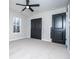 Bedroom features carpet, ceiling fan, and closet with black doors, offering comfort and ample storage at 90 Ayers Rd, Bowdon, GA 30108