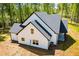 Rear aerial of the home highlighting the covered back porch and white siding with dark trim and roof at 90 Ayers Rd, Bowdon, GA 30108
