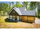 Rear view of a craftsman home featuring dark trim, covered patio, and wood design elements at 90 Ayers Rd, Bowdon, GA 30108