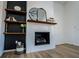 Close-up of modern fireplace with wooden shelves, decorations, and hardwood floors at 90 Ayers Rd, Bowdon, GA 30108