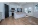 Bright kitchen features white cabinets, stainless appliances, center island, and hardwood floors at 90 Ayers Rd, Bowdon, GA 30108