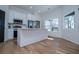 Bright kitchen boasts white cabinets, stainless appliances, a center island, and views of the lush landscaping at 90 Ayers Rd, Bowdon, GA 30108