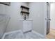 Modern laundry room featuring rustic open shelves, sleek fixtures, and stylish gray floor tiling at 90 Ayers Rd, Bowdon, GA 30108