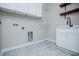 Efficient laundry room with stylish gray tile flooring, white cabinets, and modern fixtures at 90 Ayers Rd, Bowdon, GA 30108