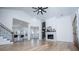 Bright living room features wood floors, fireplace, and vaulted ceiling with fan at 90 Ayers Rd, Bowdon, GA 30108