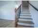 Elegant staircase with wooden treads, white risers, and a decorative metal railing leading upstairs at 90 Ayers Rd, Bowdon, GA 30108