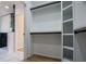 Adjacent walk-in closet, featuring modern black closet rods, with view of the adjacent bathroom at 90 Ayers Rd, Bowdon, GA 30108