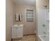 Modest bathroom featuring a white vanity, window, and combined shower and tub at 1744 Cum Laude Way, Lawrenceville, GA 30044