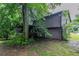 Exterior view of the back of the home with mature trees and side patio at 1744 Cum Laude Way, Lawrenceville, GA 30044