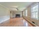 Spacious living room featuring a brick fireplace, large windows, and hardwood flooring at 1744 Cum Laude Way, Lawrenceville, GA 30044