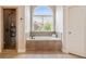 Bathroom featuring a soaking tub under a large window and a glass-enclosed shower at 1860 Leighton Ln, Marietta, GA 30062
