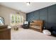 Beautifully appointed Bedroom with a blue accent wall, a wooden crib, and a comfortable recliner chair at 1860 Leighton Ln, Marietta, GA 30062