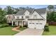 Stately two-story home with white siding, a covered front porch, dormer windows, and a well-maintained front lawn at 1860 Leighton Ln, Marietta, GA 30062