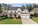 Charming two-story home with a manicured lawn, covered front porch, dormers, and a two-car garage at 1860 Leighton Ln, Marietta, GA 30062