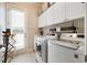 Well-lit laundry room featuring modern washer and dryer, ample storage, and easy access to the outdoors at 1860 Leighton Ln, Marietta, GA 30062