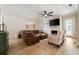 Open-concept living room with hardwood floors, leather seating, a stone fireplace, and ample natural light at 1860 Leighton Ln, Marietta, GA 30062