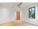 Bright bedroom featuring light wood floors, white walls, ceiling fan and wood door at 16 Bonnie Ln, Atlanta, GA 30328