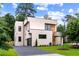 Contemporary two-story home with a clean, modern design, dark garage door, and lush landscaping at 16 Bonnie Ln, Atlanta, GA 30328
