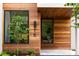 Home's front entrance featuring wood paneling, modern windows, and manicured landscaping at 16 Bonnie Ln, Atlanta, GA 30328
