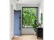 Foyer featuring a modern blue door, black accent table, and large picture window at 16 Bonnie Ln, Atlanta, GA 30328