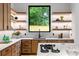 Contemporary kitchen showcasing wood cabinetry, marble countertops, and floating shelves at 16 Bonnie Ln, Atlanta, GA 30328