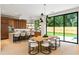 Open-concept kitchen featuring wood cabinets, island with seating, and a dining table by large windows overlooking the backyard at 16 Bonnie Ln, Atlanta, GA 30328