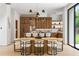 Open-concept kitchen featuring wood cabinets, island with seating, and a dining table by large windows overlooking the backyard at 16 Bonnie Ln, Atlanta, GA 30328