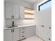 Bright laundry room with modern cabinetry, stylish floating shelves, and sink at 16 Bonnie Ln, Atlanta, GA 30328