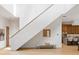 Modern staircase with wooden steps, white walls, and a view into the stylish kitchen at 16 Bonnie Ln, Atlanta, GA 30328