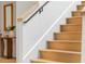 Detailed staircase with natural wood steps, a black railing, and a view of a console table at 16 Bonnie Ln, Atlanta, GA 30328