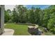A lush green backyard featuring a stone retaining wall and mature trees, offering a serene outdoor space at 893 Somersby Dr, Dallas, GA 30157