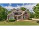 Beautiful two-story home featuring a brick and stone facade, covered porch, and meticulously maintained landscaping at 893 Somersby Dr, Dallas, GA 30157