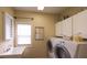 Bright laundry room with built-in cabinets and modern appliances at 893 Somersby Dr, Dallas, GA 30157