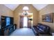 Cozy living room with a vaulted ceiling, chandelier, large TV, and comfortable leather seating at 893 Somersby Dr, Dallas, GA 30157