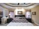 Elegant main bedroom with neutral colors, a tray ceiling, and decorative lamps on nightstands at 893 Somersby Dr, Dallas, GA 30157